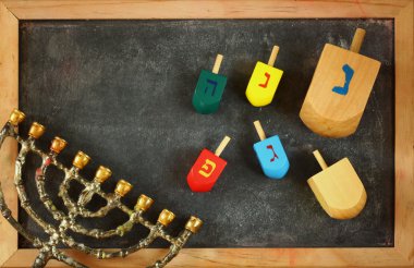 Yahudi tatil Hanukkah menorah (geleneksel Mumluk) ve ahşap renkli sevinçler (iplik üst) üzerinden kara tahta arka plan ile görüntü.