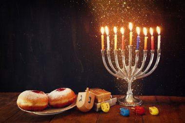 image of jewish holiday Hanukkah with menorah (traditional Candelabra), donuts and wooden dreidels (spinning top). clipart