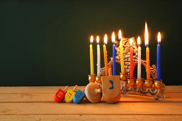 Η εικόνα της εβραϊκής διακοπές Hanukkah με menorah (παραδοσιακό μανουάλια) και ξύλινα ντρέιντελ (σβούρα). ρετρό φιλτραρισμένο εικόνα. — Φωτογραφία Αρχείου