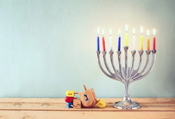 Abaixo a imagem-chave de férias judaicas Hanukkah com menorah (Candelabra tradicional) e dreidels de madeira (topo girando ). — Fotografia de Stock