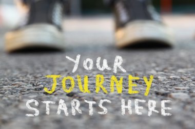 image with selective focus over asphalt road and person with handwritten text - your journey starts here. education and motivation concept.