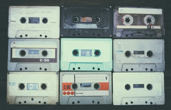 Close up photo of cassette tape over wooden table . top view. retro filtered. — 图库照片