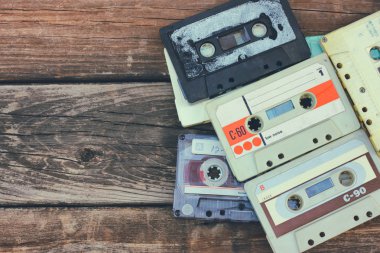 close up photo of cassette tape over wooden table . top view. retro filtered.