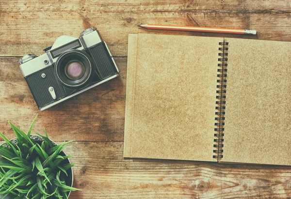 Vista superior de la imagen del cuaderno en blanco y la cámara vieja . —  Fotos de Stock