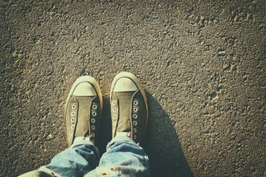 kişinin asfalt yol üzerinde ayakkabı ile üstten görünüm görüntüsü.