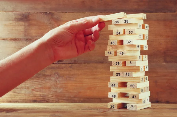 Manlig hand utsläppande av trä block på ett torn. hyvling och strategi koncept. — Stockfoto