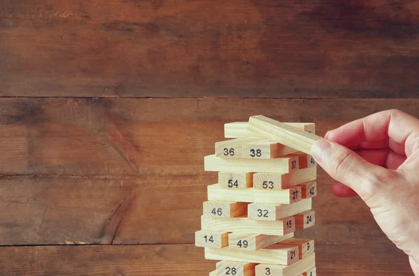 Mano masculina colocando bloque de madera en una torre. concepto de planificación y estrategia . — Foto de Stock