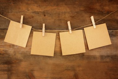 Blank tags hanging on wooden background.