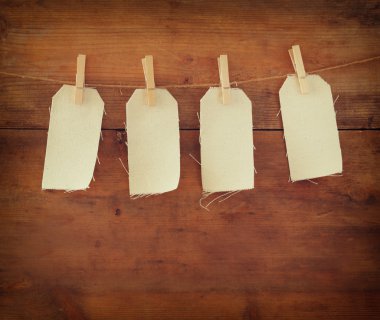 Blank tags hanging on wooden background.