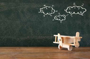 eski ahşap uçak oyuncak infographics dokulu kara tahta üzerine kümesinin önünde ahşap masa üzerinde görüntü.