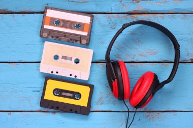 top view of vintage headphones and cassettes over aqua wooden table. retro filtered. clipart