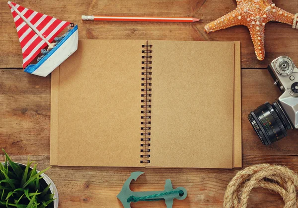 Top view image of open blank notebook, wooden sailboat, nautical rope and camera. travel and adventure concept. retro filtered image. — Φωτογραφία Αρχείου