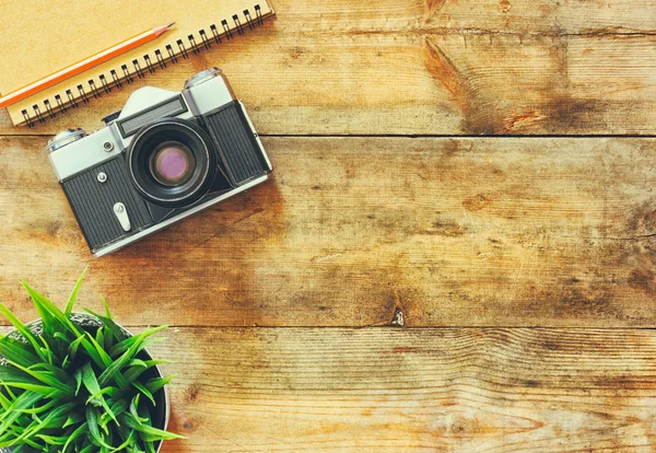 Bovenaanzicht beeld van lege notebook en oude camera. Retro gefilterd. — Stockfoto