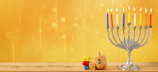 website banner image of of jewish holiday Hanukkah with menorah (traditional Candelabra). retro filtered. glitter overlay.
