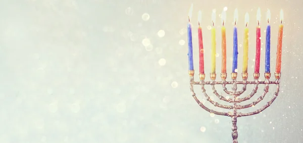 website banner image of of jewish holiday Hanukkah with menorah (traditional Candelabra). retro filtered. glitter overlay.