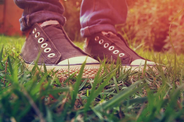 Groene gras en personen schoenen — Stockfoto