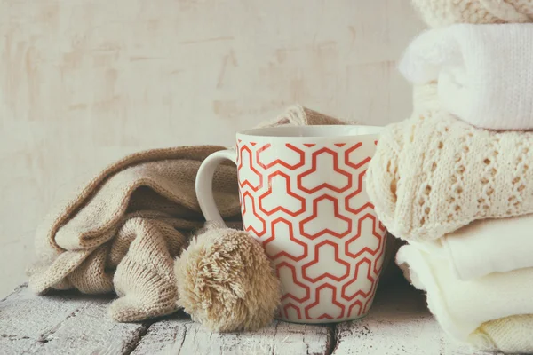 Knitted sweaters next to cup of coffee — Stock Photo, Image