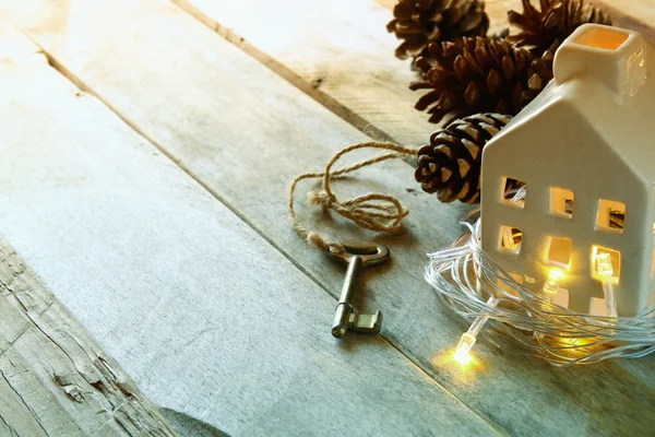 Afbeelding van kleine miniatuur huis en oude sleutel over rustieke houten tafel. — Stockfoto