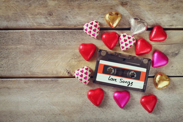 Top view image of colorful heart shape chocolates and audio cassette on wooden table. valentine's day celebration concept — Zdjęcie stockowe