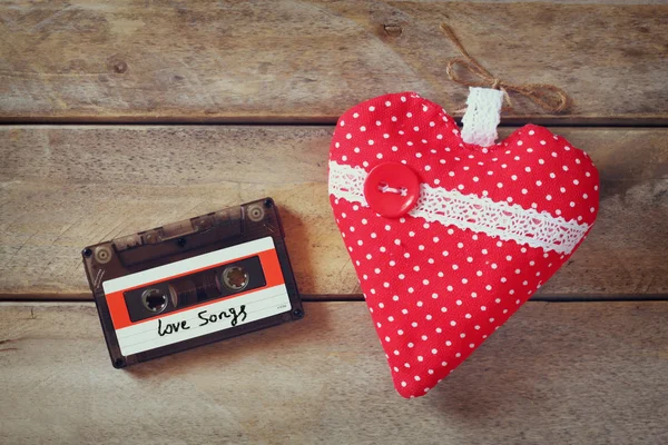 Top view image of red fabric heart and audio cassette on wooden table. valentine's day celebration concept. — Stockfoto