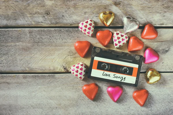 Imagen de vista superior de colores en forma de corazón chocolates y cassette de audio en la mesa de madera. concepto de celebración del día de San Valentín — Foto de Stock