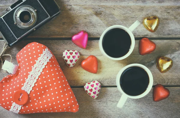 Top view image of colorful heart shape chocolates, fabric heart and couple mugs of coffee on wooden table. valentine's day celebration concept. — 图库照片
