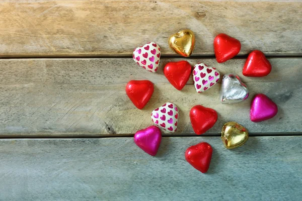 Image de vue de dessus de chocolats colorés en forme de coeur sur une table en bois. concept de célébration de la Saint-Valentin. image rétro filtrée et tonique . — Photo