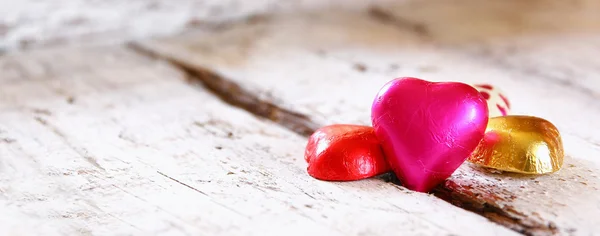 나무 테이블에 다채로운 심장 모양 초콜렛의 웹사이트 배너 이미지입니다. 발렌타인의 날 축 하 개념. — 스톡 사진