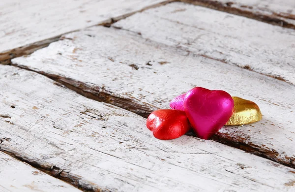 Image de vue de dessus de chocolats colorés en forme de coeur sur une table en bois. concept de célébration de la Saint-Valentin. image rétro filtrée et tonique . — Photo