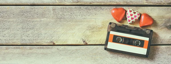 Website banner image of colorful heart shape chocolates and audio cassette on wooden table. valentine's day celebration concept. retro toned and filtered. — Stockfoto