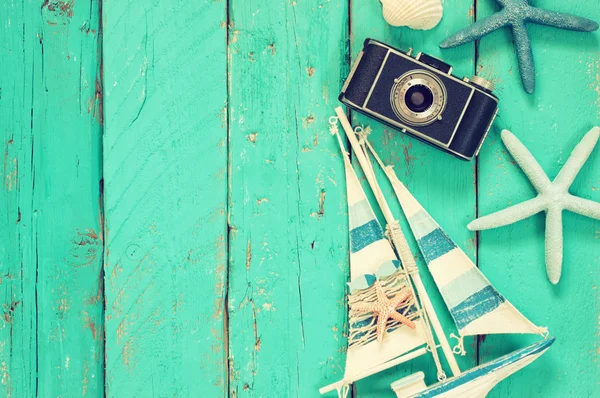 photo camera, wood boat, sea shells