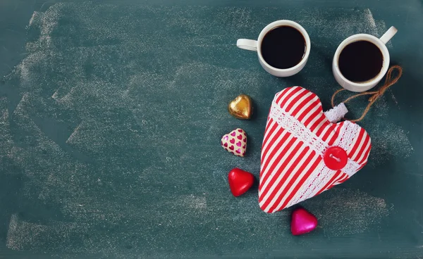 顶视图图像的彩色心形状巧克力，咖啡上黑板背景织物的心和几个杯子。情人节那天庆祝概念 — 图库照片