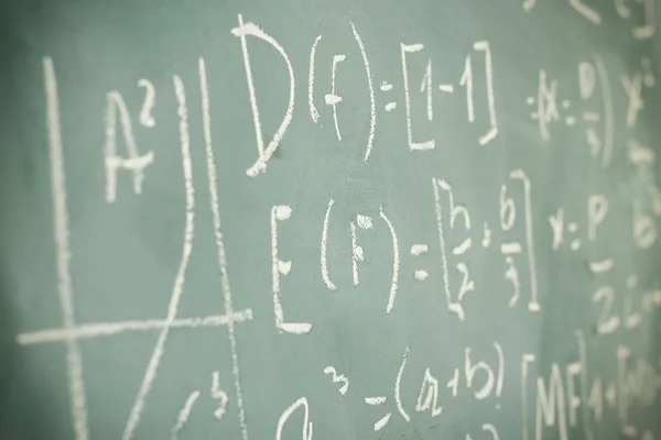 Sidovy av matematiska formler och beräkningen skrivs över chalboard. selektiv inriktning. — Stockfoto