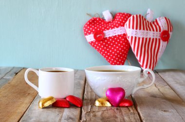 çekici kırmızı kalp şekli çikolata ve iki bardak kahve ahşap masa üzerinde görüntü. Sevgililer günü kutlama kavramı. Filtre vintage