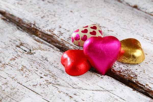 Top view image of colorful heart shape chocolates on wooden table. valentine's day celebration concept. selective focus — Stockfoto
