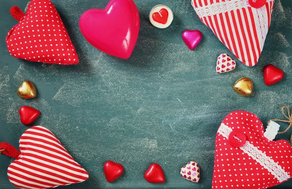 Imagen de vista superior de chocolates en forma de corazón de colores en el fondo de pizarra. concepto de celebración del día de San Valentín — Foto de Stock