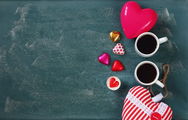 顶视图的多彩的心形状巧克力和几杯咖啡上黑板背景的图像。情人节那天庆祝概念 — 图库照片
