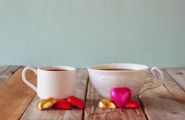 çekici kırmızı kalp şekli çikolata ve iki bardak kahve ahşap masa üzerinde görüntü. Sevgililer günü kutlama kavramı. Filtre vintage