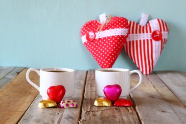 çekici kırmızı kalp şekli çikolata ve iki bardak kahve ahşap masa üzerinde görüntü. Sevgililer günü kutlama kavramı. Filtre vintage