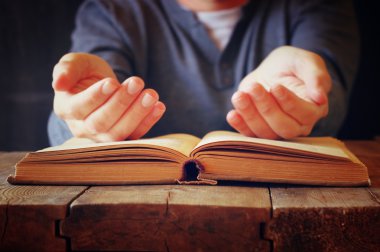 dua kitabı yanında oturan kişinin düşük anahtar görüntüsü