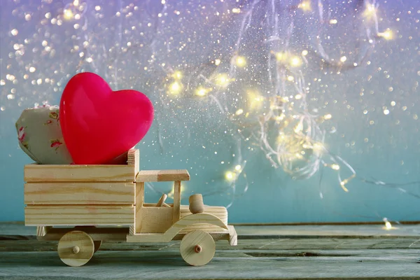 Foto de caminhão de brinquedo de madeira com corações na frente do quadro. Conceito de celebração do dia dos namorados. vintage filtrado — Fotografia de Stock