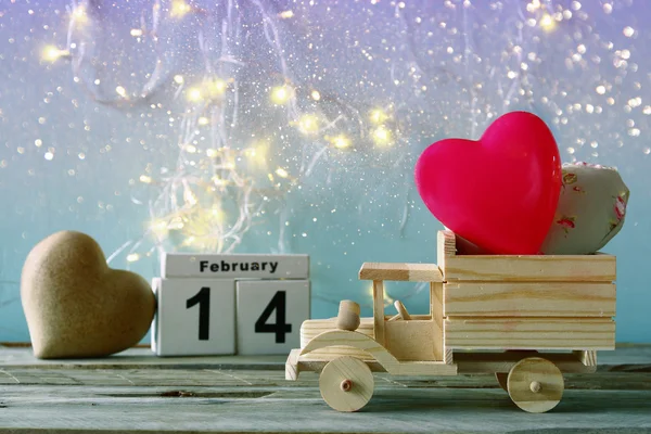 Photo du 14 février calendrier vintage en bois avec camion jouet en bois avec des cœurs en face du tableau. concept de célébration de la Saint-Valentin. vintage filtré — Photo