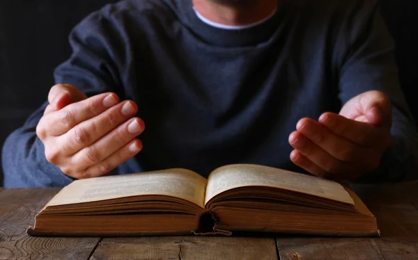 Imagem chave baixa da pessoa sentada ao lado do livro de orações — Fotografia de Stock