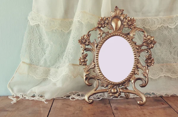 Antique blank victorian style frame on wooden table. retro filtered image. template, ready to put photography — Stock fotografie