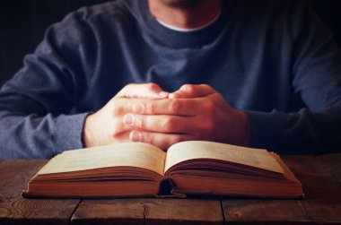 dua kitabı yanında oturan kişinin düşük anahtar görüntüsü