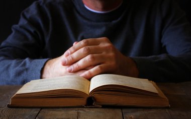 dua kitabı yanında oturan kişinin düşük anahtar görüntüsü
