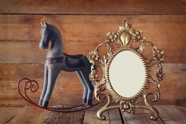 Antique quadro estilo vitoriano em branco e velho cavalo de balanço sobre mesa de madeira . — Fotografia de Stock