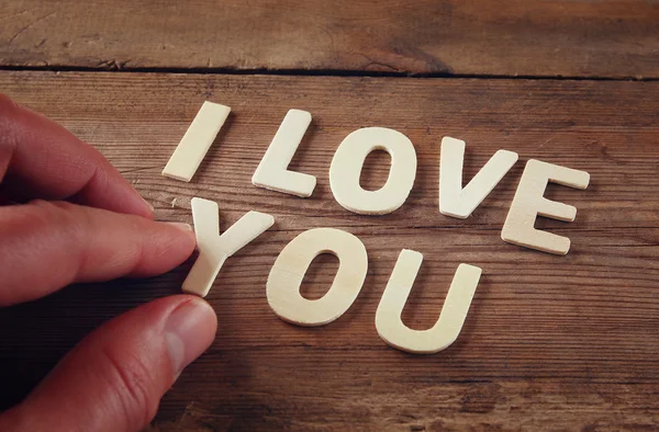 Foto messa a fuoco selettiva delle parole "ti amo" fatta con lettere di legno blocco su sfondo di legno. concetto di festa di San Valentino . — Foto Stock