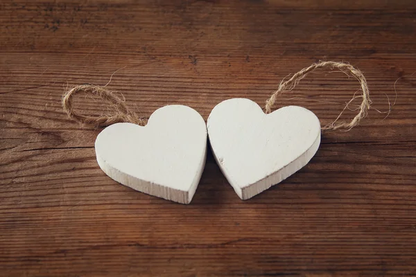 Selective focus photo of couple of wooden hearts on rustic table.  valentine's day celebration concept. vintage filtered and toned — Stock Photo, Image