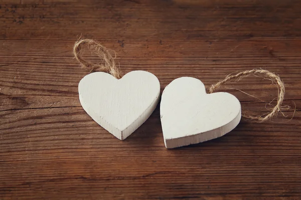 Selective focus photo of couple of wooden hearts on rustic table.  valentine's day celebration concept. vintage filtered and toned — 스톡 사진